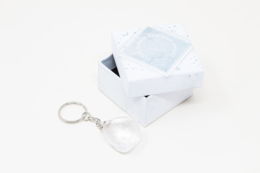Clear quartz amulet laying next to its white box.